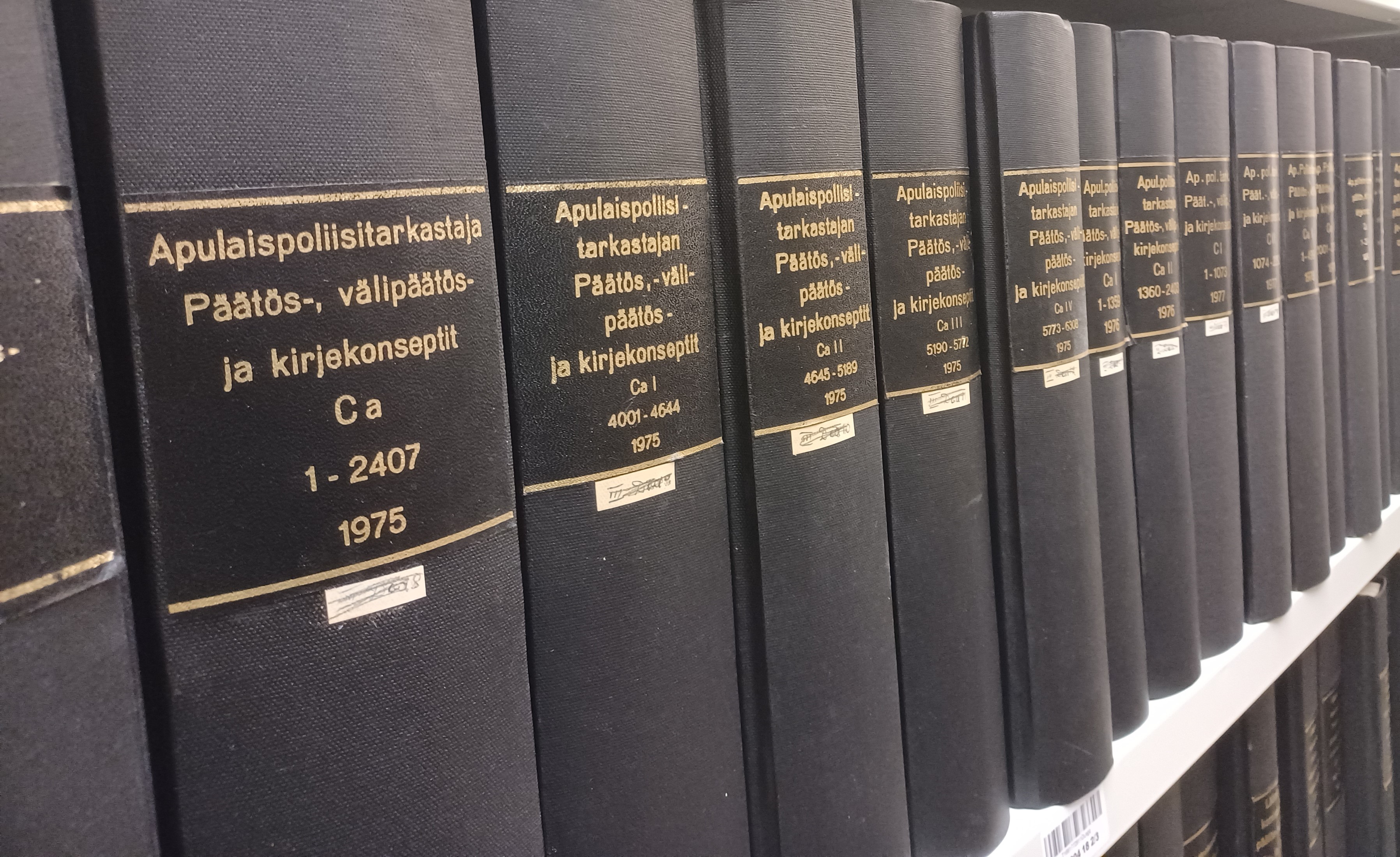 Arkistohyllyssä on rivi mustia kirjoja, joiden selkämykseen on painettu arkistoyksikköjen tiedot.